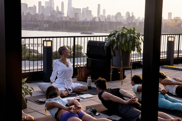 Paavo Siljamäki of Above & Beyond, and Elena Brower lead a rooftop yoga session in NYC on July 5, in collaboration with Amazon Music. Photo by Jamie Rosenberg.