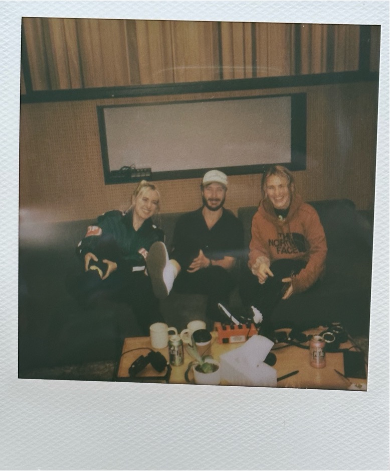 [From left to right: Lenii, Victor, and Linney on the day they wrote “Opposites.” All are holding their leg in solidarity with Linney, who was still in a leg brace.]
